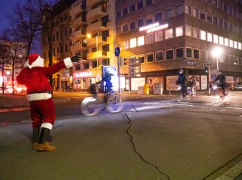 Nikolaus übergibt radelnden Passanten Geschenke