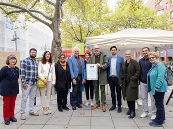 Manfred Holz, Ehrenbotschafter Fairtrade Deutschland e.V. (rechts) überreicht die Urkunde »10 Jahre Fairtrade-Town« an Oberbürgermeister Dr. Peter Kurz und den Steuerungskreis Fairtrade-Town Mannheim.