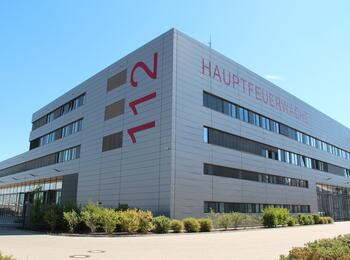 Das Bild zeigt die Hauptfeuerwache Mannheim. Auf der linken Gebäudeseite ist die europäische Notrufnummer 112 lesbar