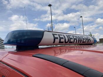 Billd zeigt einen sogenannten Blaulichtbalken auf dem Dach einer Fahrzeugs. Zwischen den Blaulichtern ist die Aufschrift Feuerwehr zu lesen