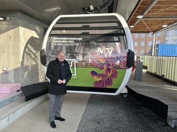 Oberbürgermeister Specht vor einer Gondel der BUGA-Seilbahn