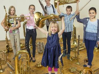 Kinder halten Blasinstrumente in die Höhe