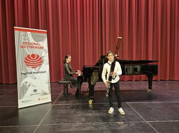 Kind spielt Klavier, anderes Kind spielt Fagott