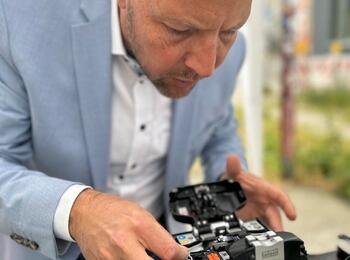 Bürgermeister Dr. Proffen legt selbst Hand an und hilft beim Spleißen der Glasfaserkabel.