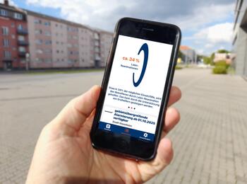 Eine Hand hält ein Handy. Auf dem Bildschirm ist die App Katretter zu sehen. Ein Text besagt, dass die gebietsübergreifende Alarmierung ab 01.10.2025 verfügbar ist