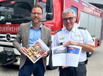 Bürgermeister und Sicherheitsdezernent Dr. Volker Proffen und stv. Feuerwehr-Kommandant Jens Stiegel mit dem Jahresbericht 2025 der Feuerwehr Mannheim.