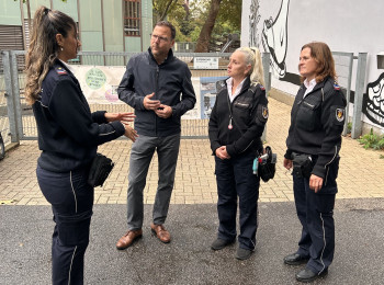 Sicherheitsbürgermeister Dr. Volker Proffen im Gespräch mit Mitarbeiterinnen des städtischen Ordnungsdienstes vor der Uhlandschule.