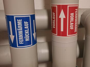 zwei Rohre mit Fernwärme in einem Keller