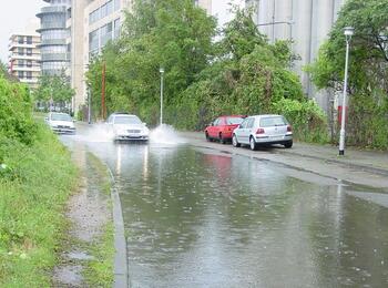 Auto fährt durch überschwemmte Straße 
