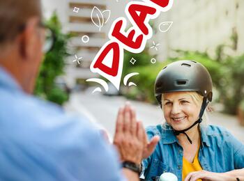 Frau mit Fahrrad klatscht sich ab mit einem Mann "Deal"