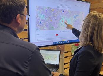 Zwei Personen schauen sich auf einem Bildschirm die online Übersichtskarte aller Deals an