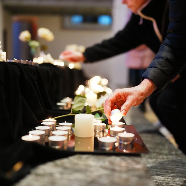 Menschen beim Kerzenaufstellen