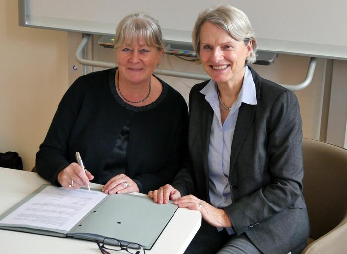 Die Geschäftsführerin des Vereins "Kinderfreundliche Kommunen", Dr. Heide-Rose Brückner, unterzeichnet im Beisein von Bürgermeisterin Dr. Ulrike Freundlieb die Vereinbarung.