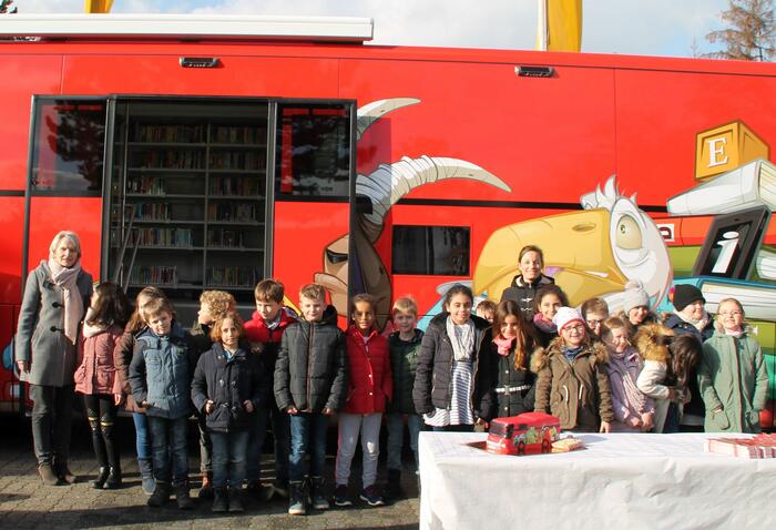 Bildungsbürgermeisterin Dr. Ulrike Freundlie mit den Schüler/-innen der Alfred-Delp-Schule und Schulleiterin Kirsten Mühlum bei der Einweihung der Mobilen Bibliothek vor dem Fahrzeug.