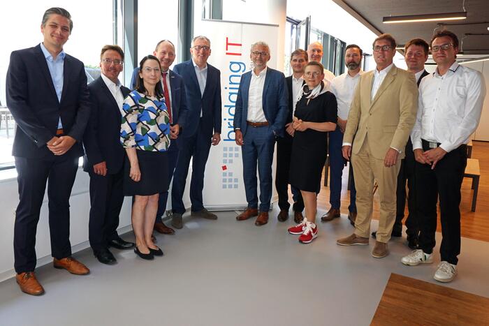 Oberbürgermeister Dr. Peter Kurz (5. v. l.) und Klaus Baumgärtner, Geschäftsführer der bridgingIT (6. v. l.) gemeinsam mit Vertretern der Stadtspitze und Wirtschaftsförderung sowie Mitarbeiterinnen und Mitarbeitern von bridgingIT
