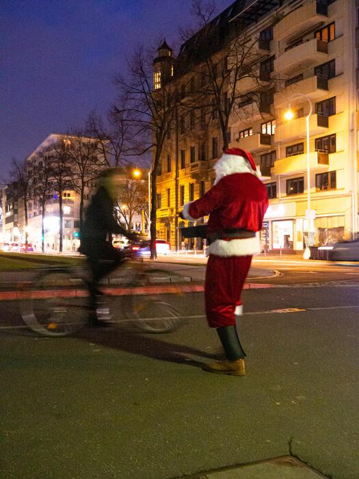Nikolaus übergibt radelnden Passanten Geschenke