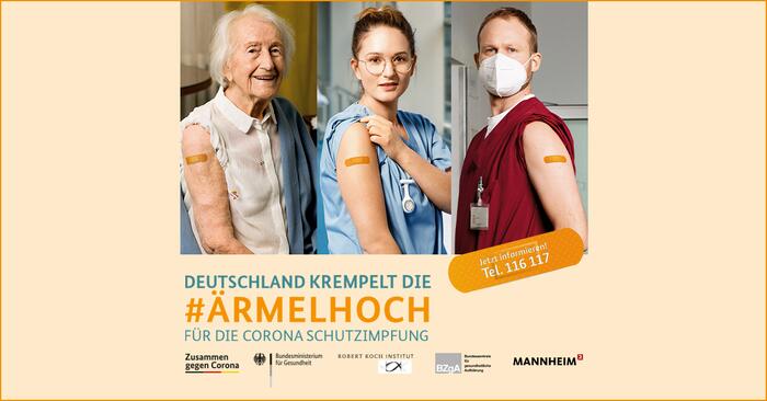 Eine ältere Frau, eine junge Pflegedienstmitarbeiterin und ein junger Pflegedienstmitarbeiter zeigen ihren Oberarm mit Impfpflaster