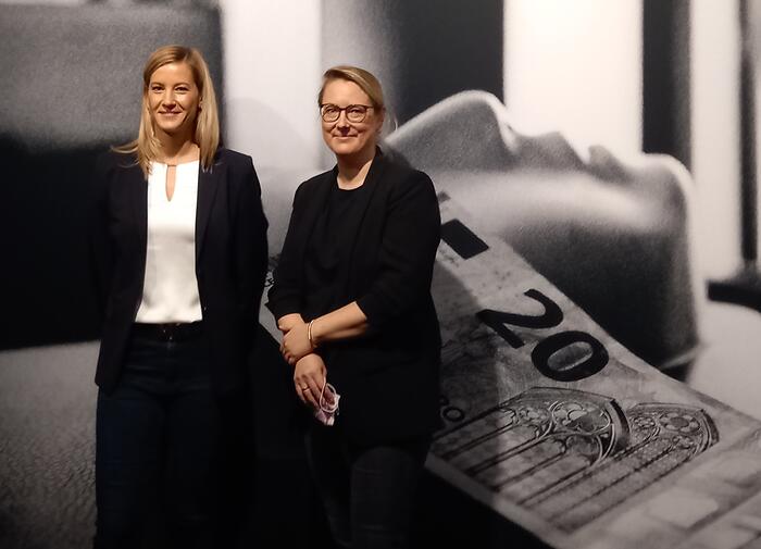 Zwei Frauen vor großflächigem Bild in Ausstellung