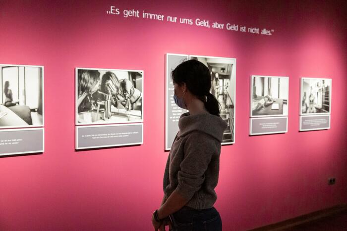 Frau schaut sich in Ausstellung Fotografien an