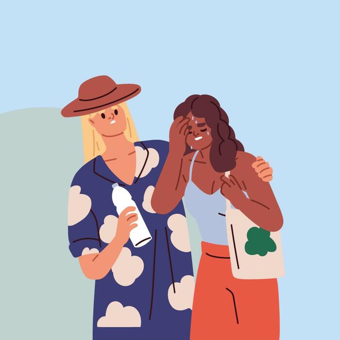 Ein Mann stützt eine Frau, der die Hitze zu schaffen macht.