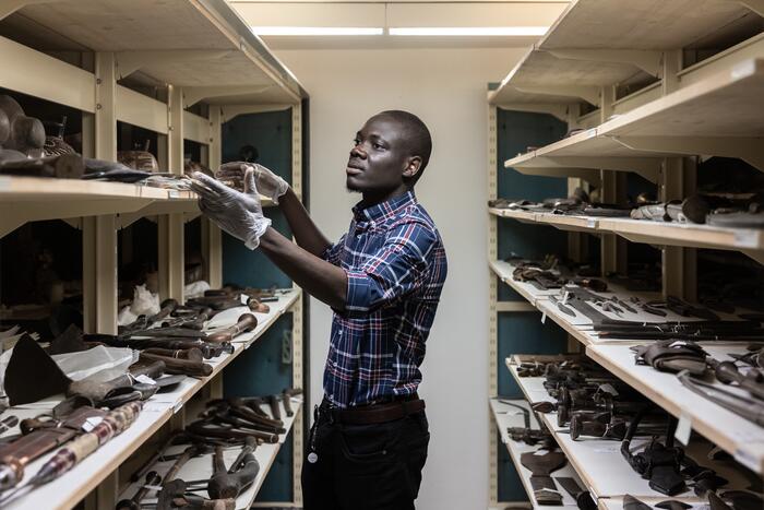 Mann sichtet Objekte im Museumsdepot