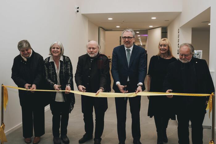 sechs Personen schneiden Band für Eröffnung durch