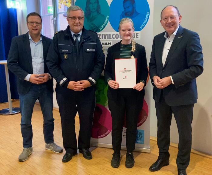 Oberbürgermeister Christian Specht (r.) überreicht mit Polizeipräsident Siegfried Kollmar (2.v.l.) und Sicherheitsdezernent Dr. Volker Proffen (l.) die Auszeichnung an Corinna Führer.