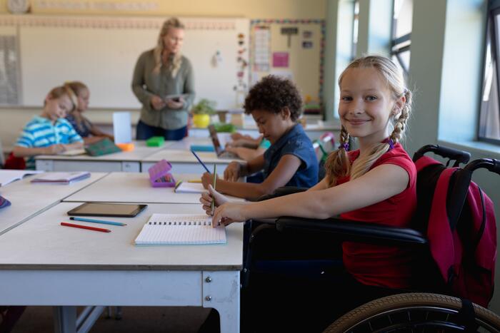 Mädchen im Rollstuhl in Klassenraum