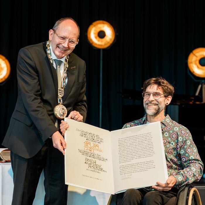 Oberbürgermeister Specht übergibt die Bertha-und-Carl-Benz-Preis-Urkunde ab Fabian Dirla